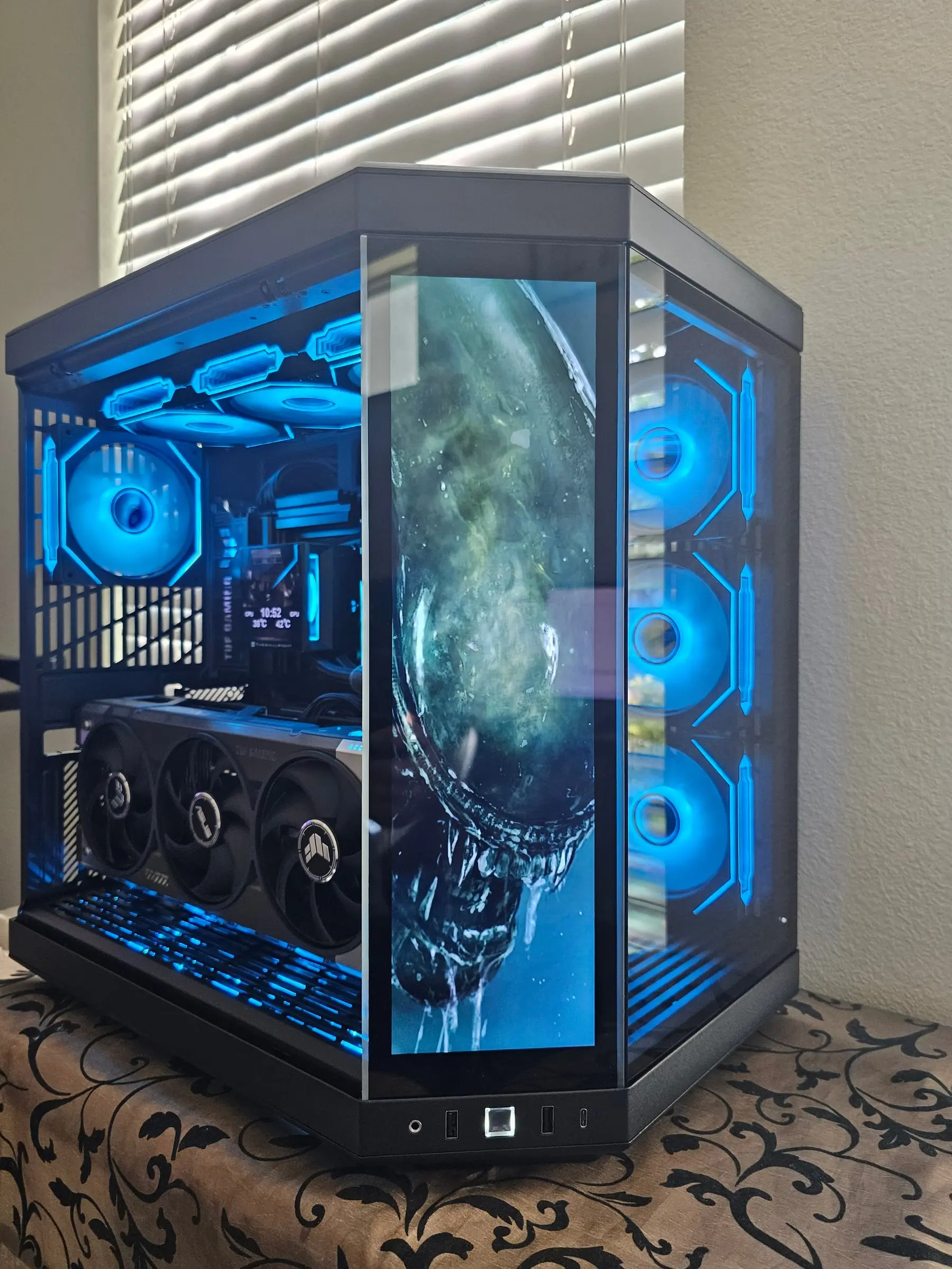 Pitch black Hyte Y70 Touch glowing ice blue with Alien xenomorph art on the front touchscreen