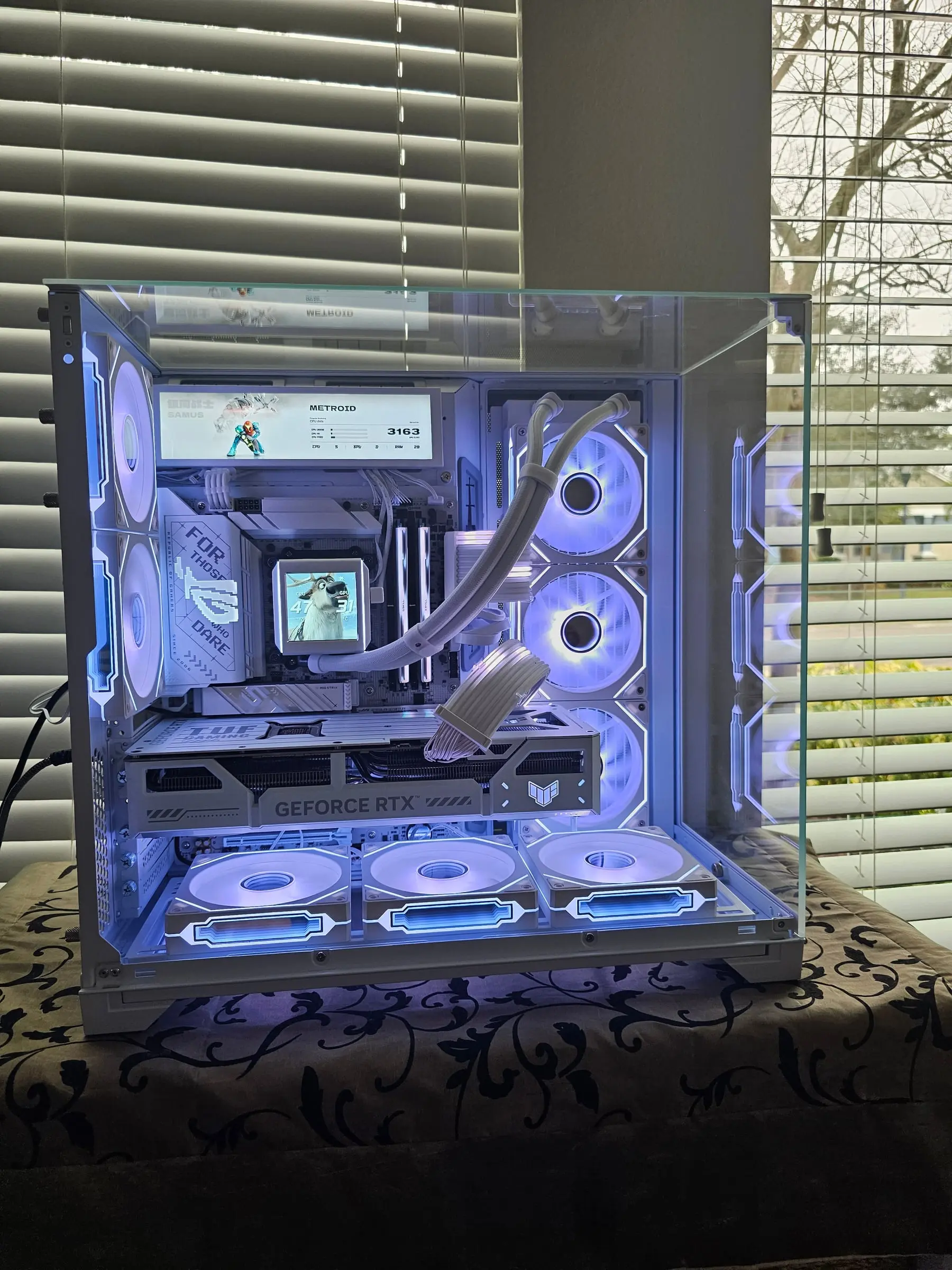 Ice-white front view — Metroid layout on the sensor panel, white TUF 5070 Ti, and the Strimer coil glowing