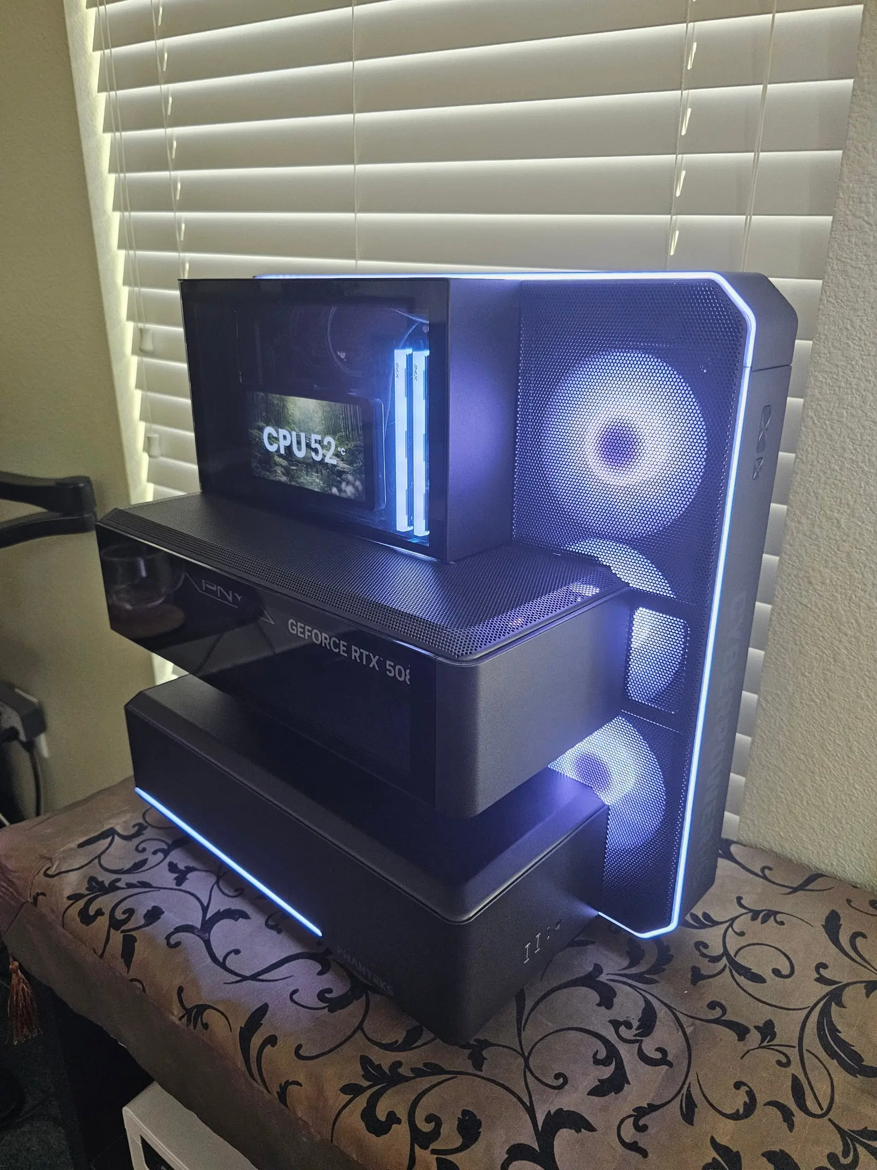 Ice-white theme — Glacier One LCD reading CPU 52°C in the top cube, XPG sticks glowing, PNY 5080 in its tray