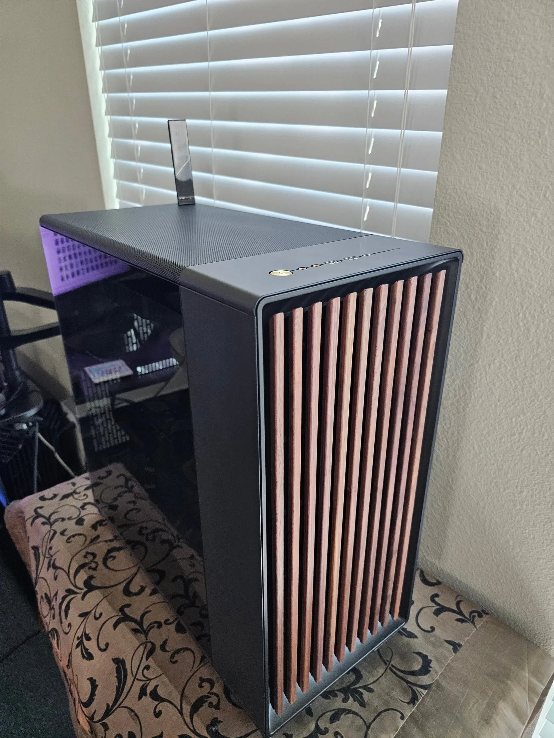 Top view of the North XL with brass power button, front I/O, and the walnut slat front