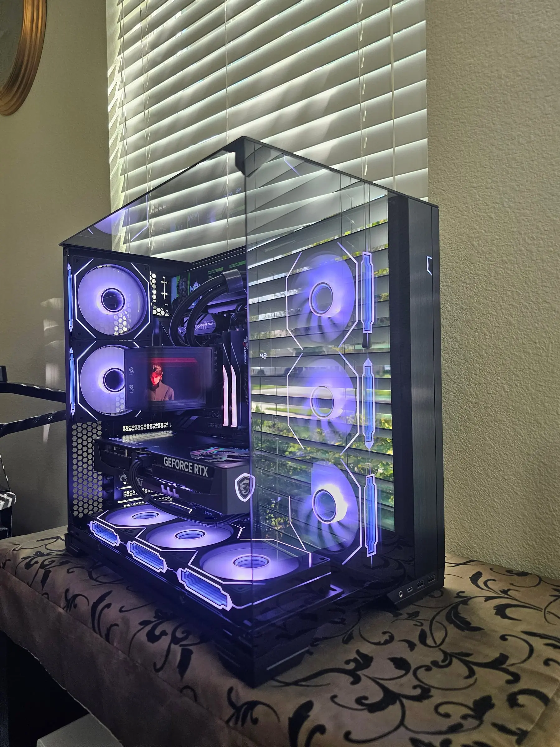 Violet theme through the tinted tri-glass — curved AMOLED clip playing above the MSI Gaming Trio card