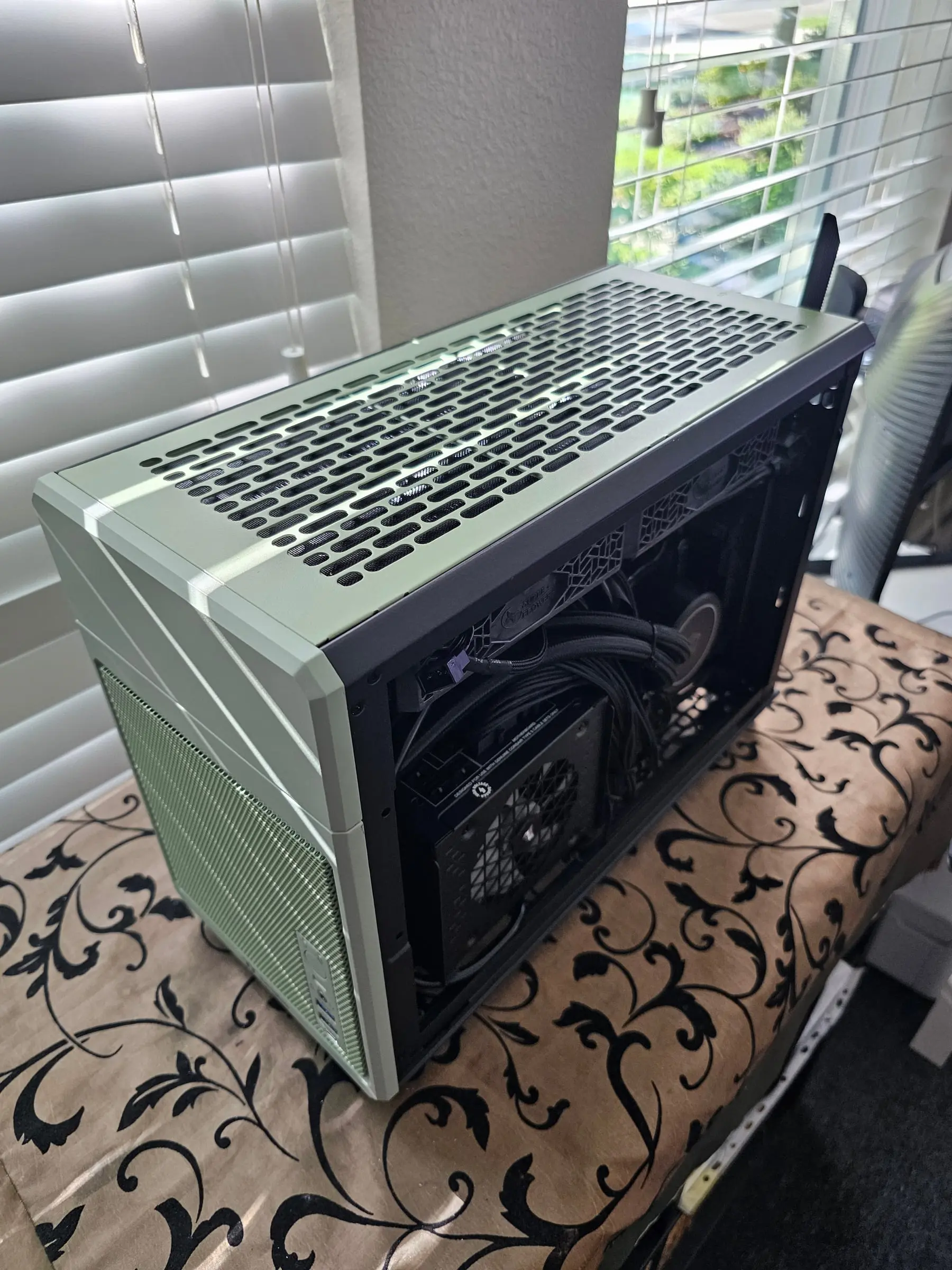 Side panel off mid-assembly, showing the power supply, cabling, and a cooler fan before final cable management