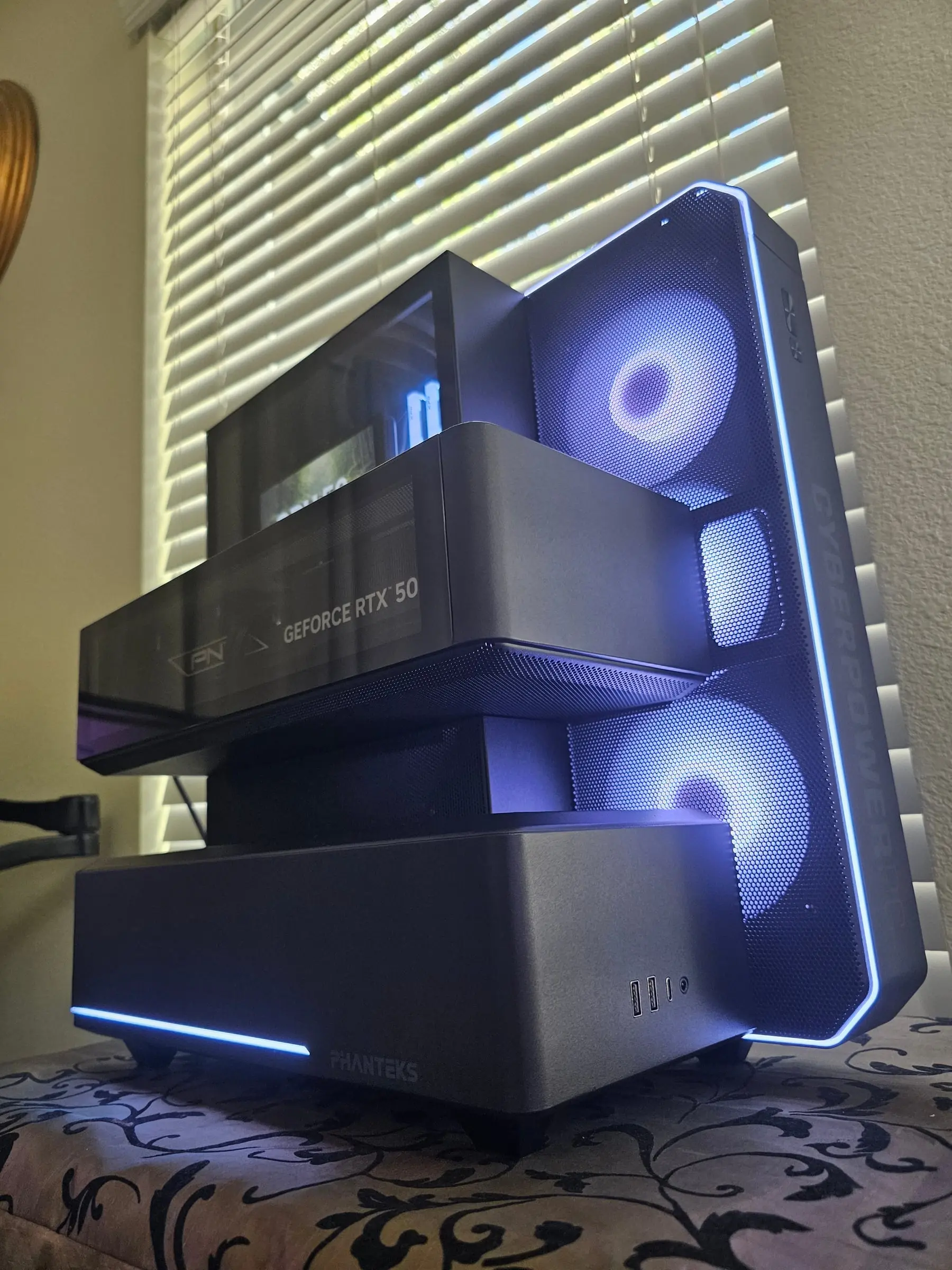 White edge glow on the exploded modules — front I/O on the PSU plinth, fan tower lit