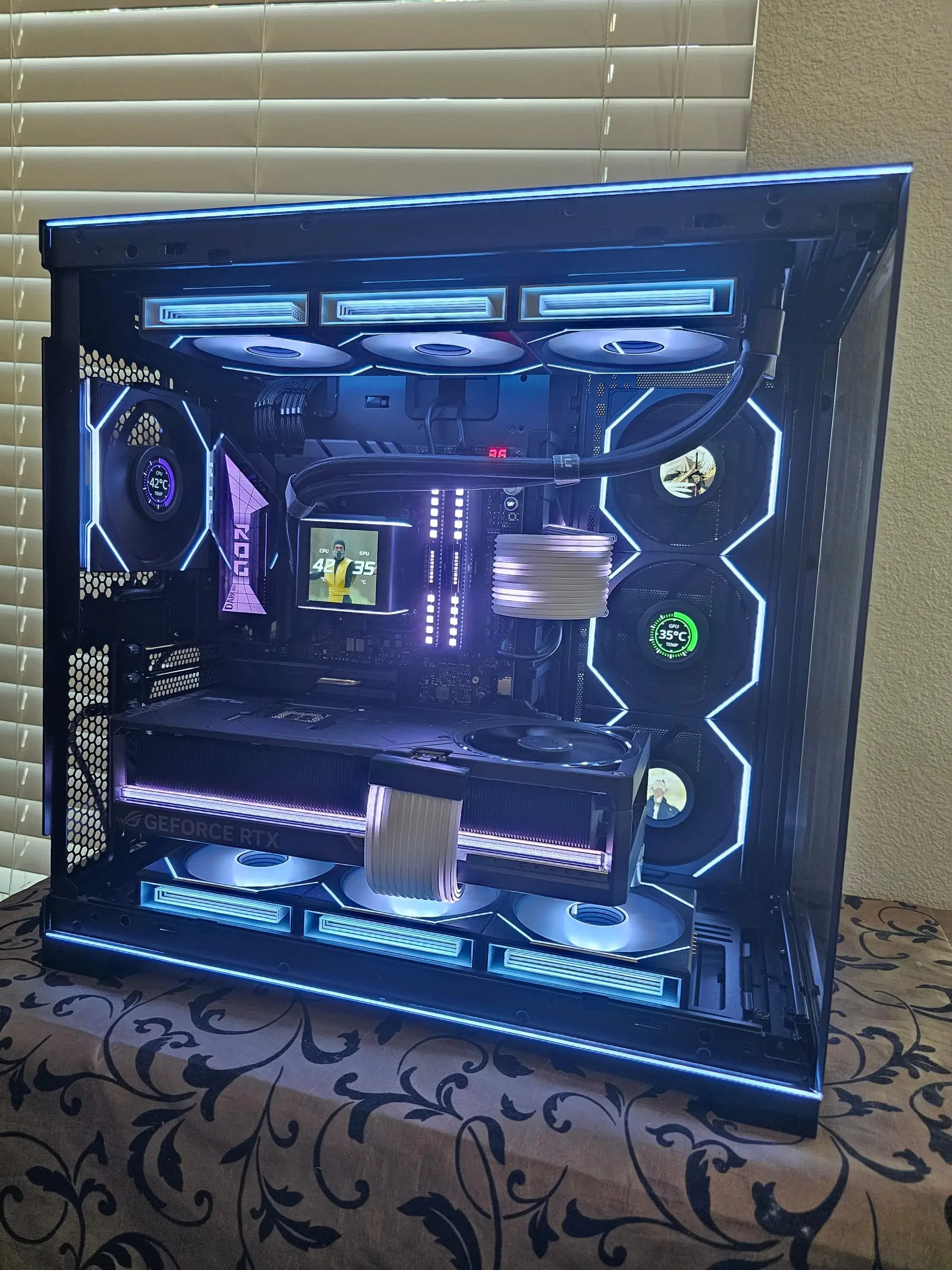 Front view with Mortal Kombat art on the pump LCD, fan screens showing art and a live GPU dial