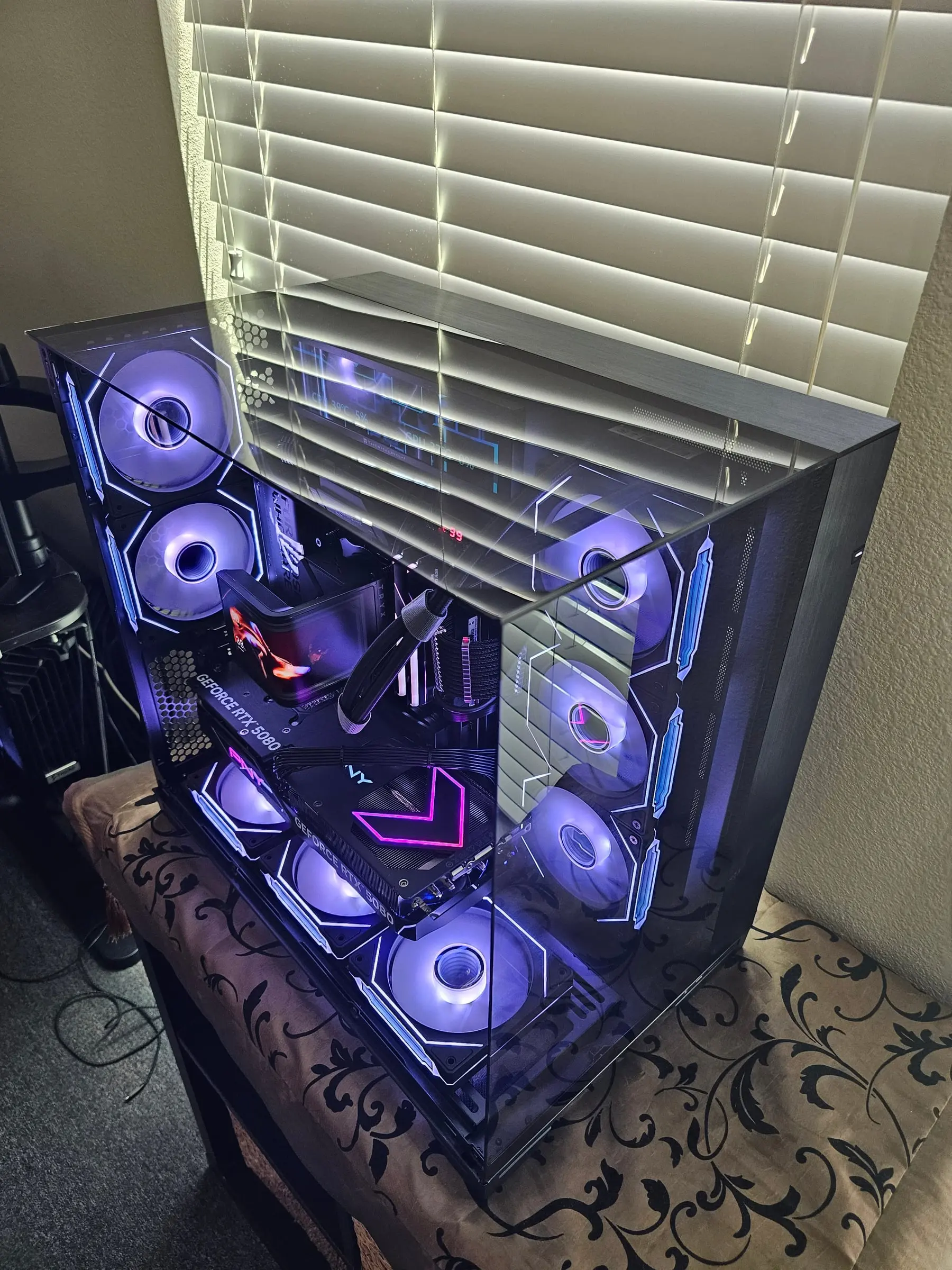 Top-down angle over the glass roof with the PNY chevron glowing pink and Prism fans in violet