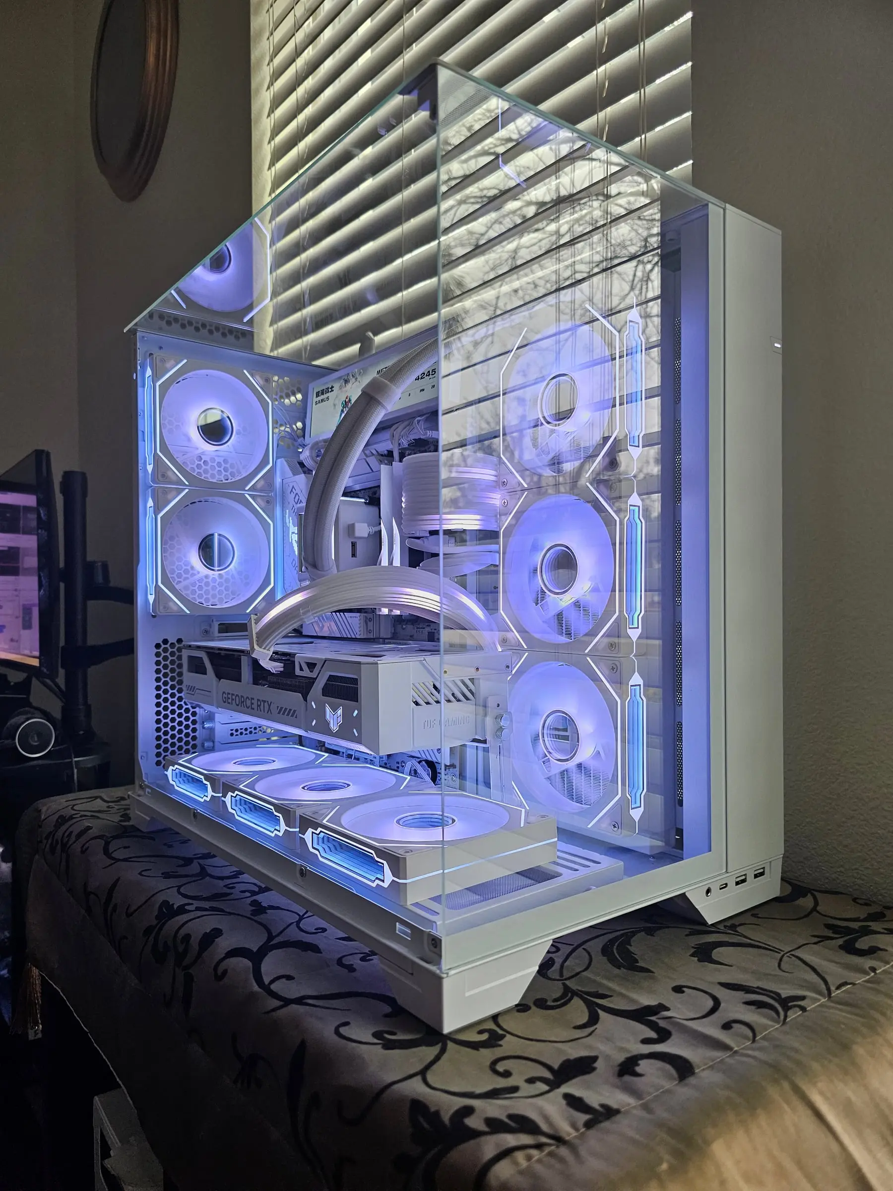 Blue-white three-quarter through the pillarless glass, both screens lit over the white chamber