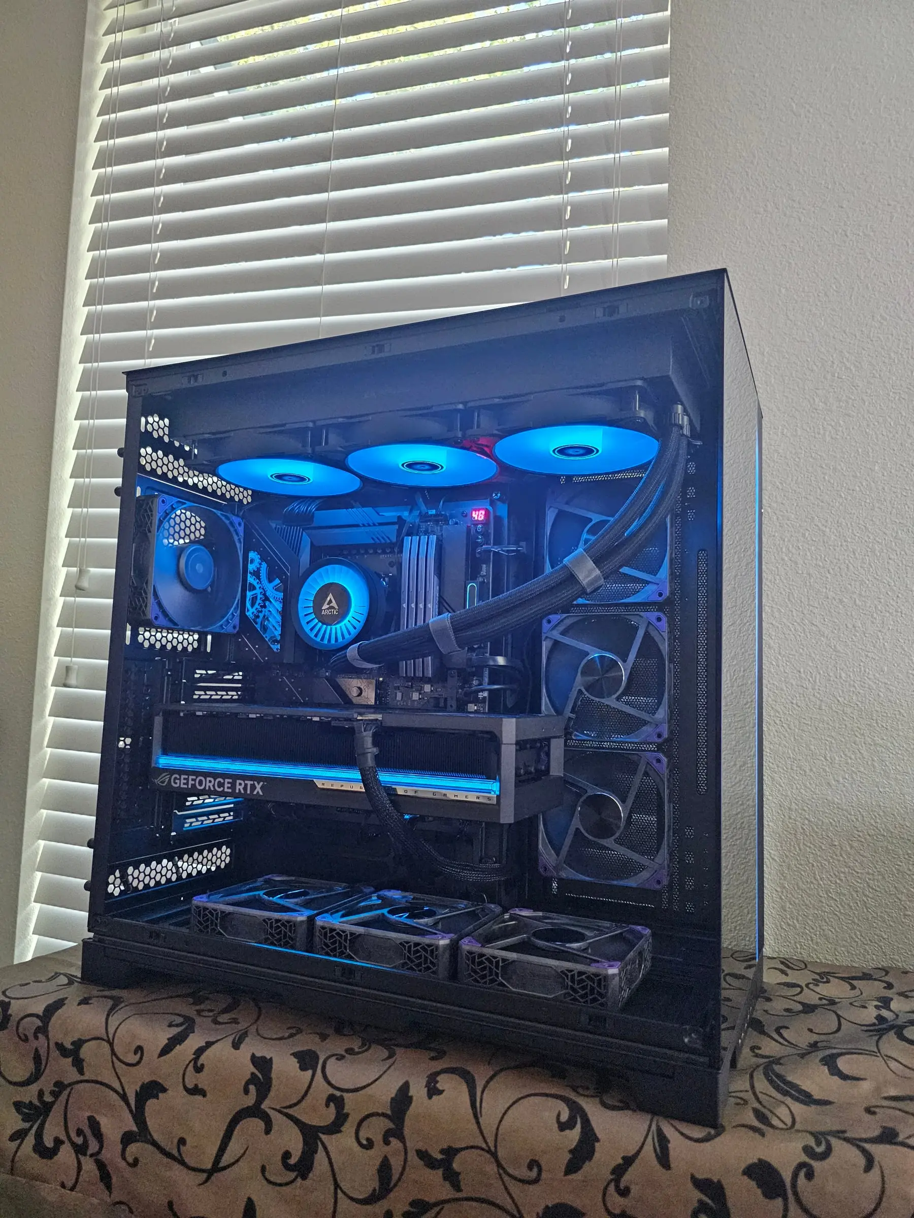 Ice-blue theme — Liquid Freezer fans glowing, Astral light bar cyan, debug display reading out