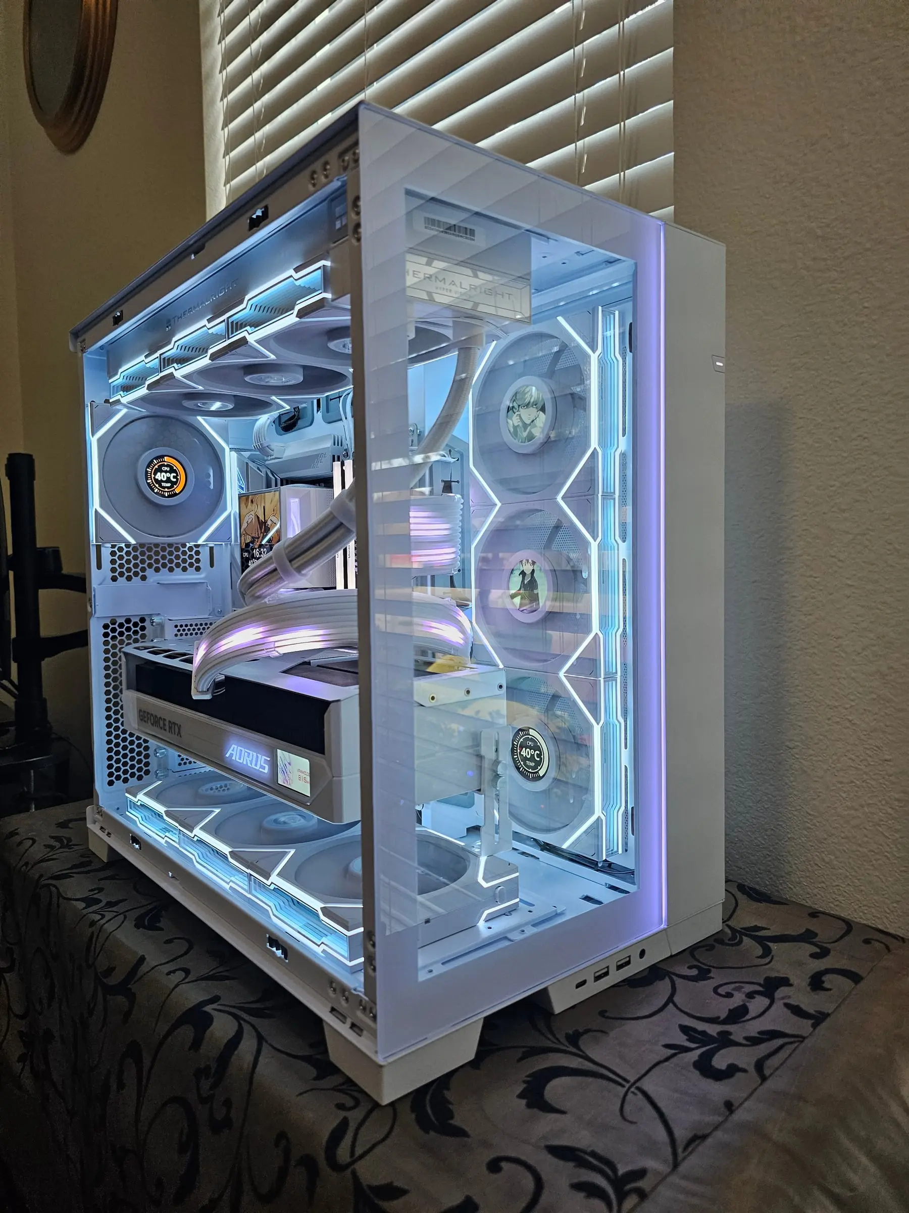 Front-left angle — Thermalright radiator bar, pump LCD showing art and temps, white Strimer arcs