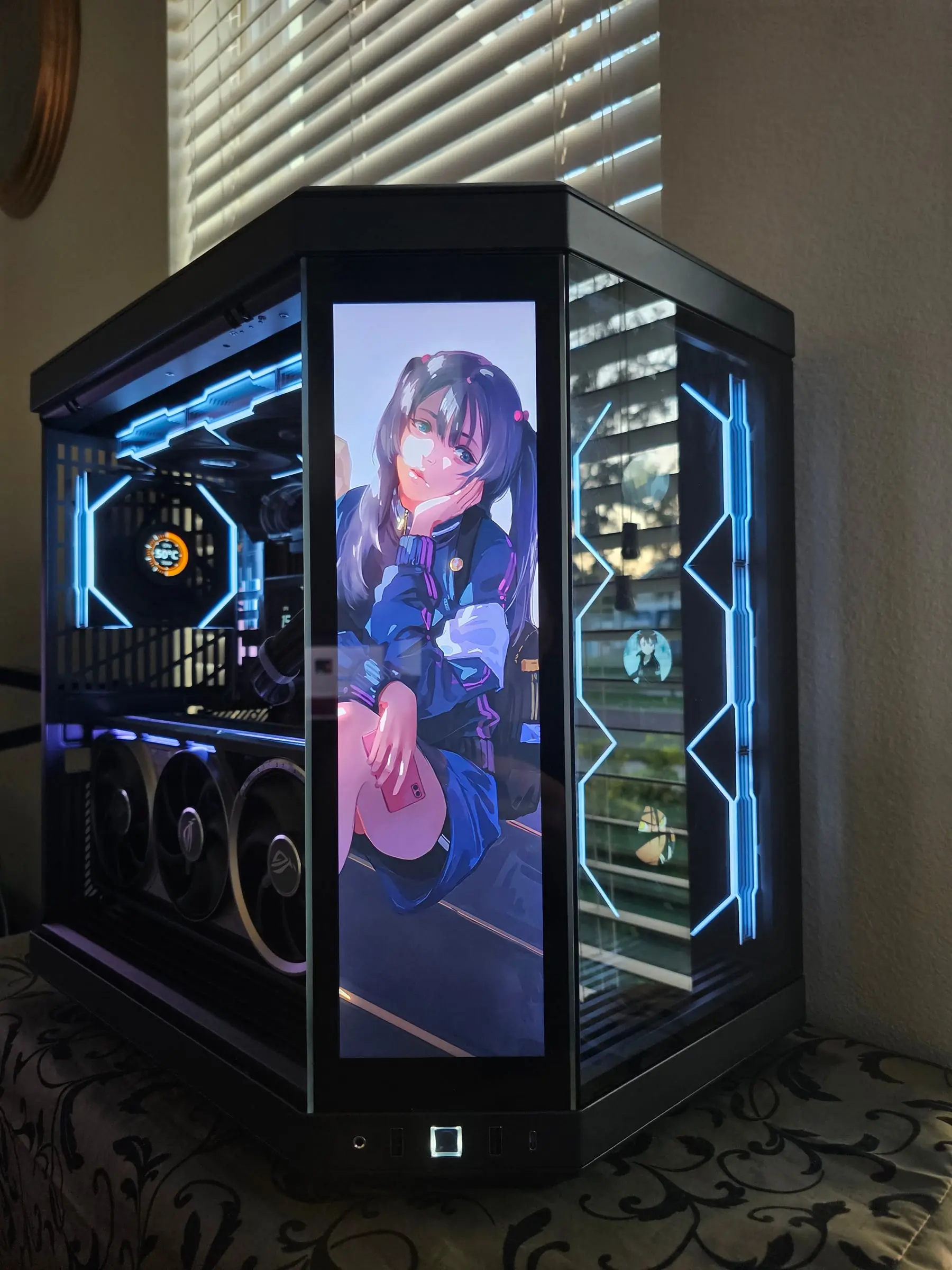 Twin-tail anime character on the front display, icy fans behind the pillarless glass