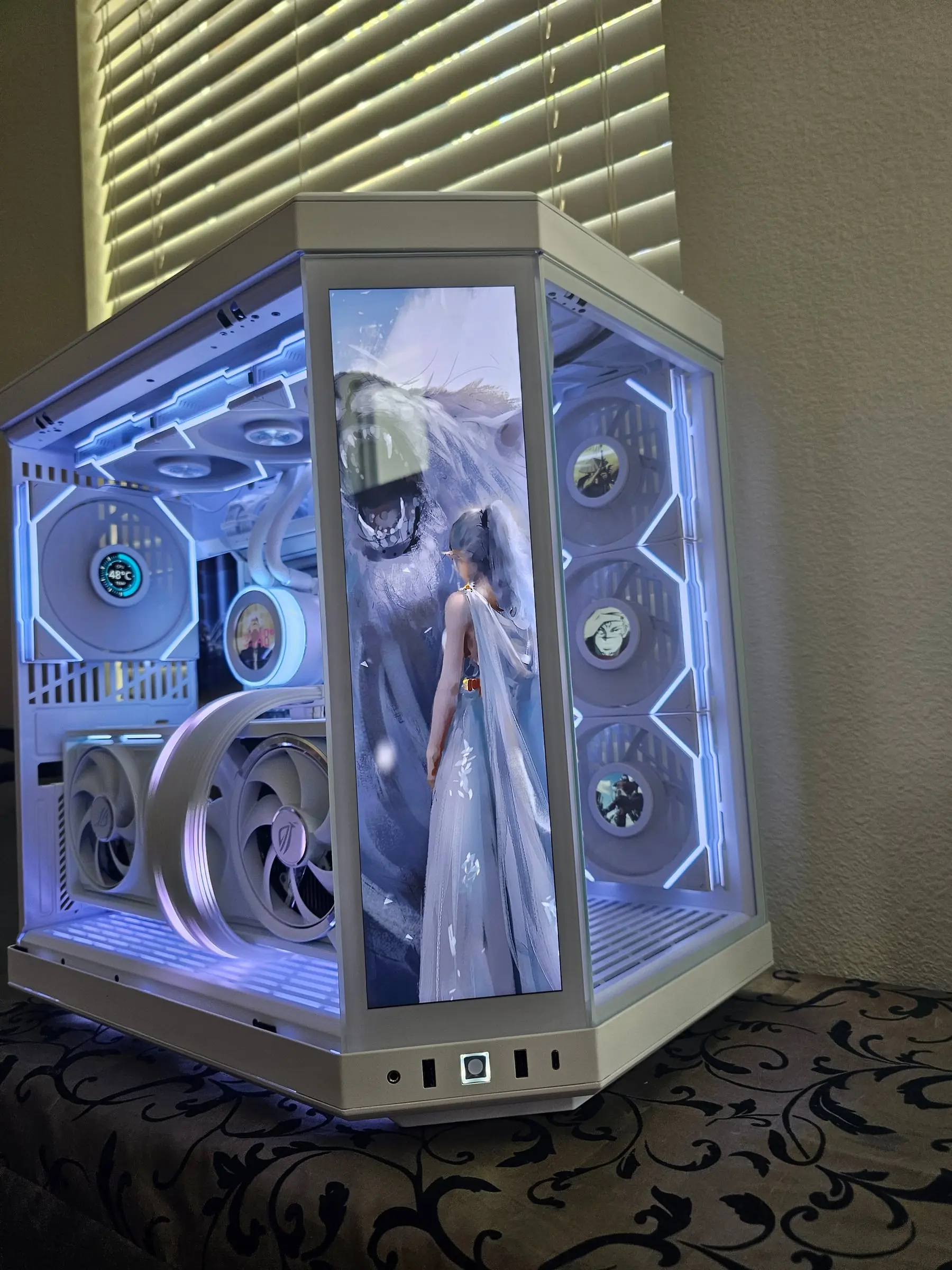 Hyte Y70 Touch White powered on in cyan — front touchscreen showing fantasy art, LCD fans, and the white RTX 5090 Astral behind glass