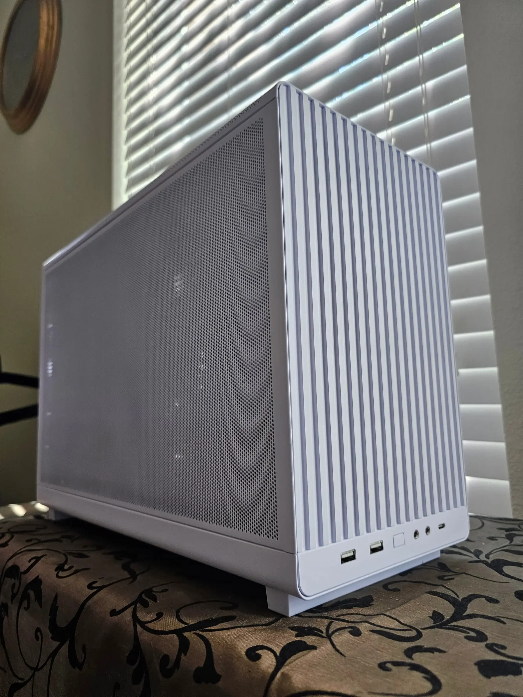 Close-up of the ridged white top panel and fine mesh front of the Lian Li A3