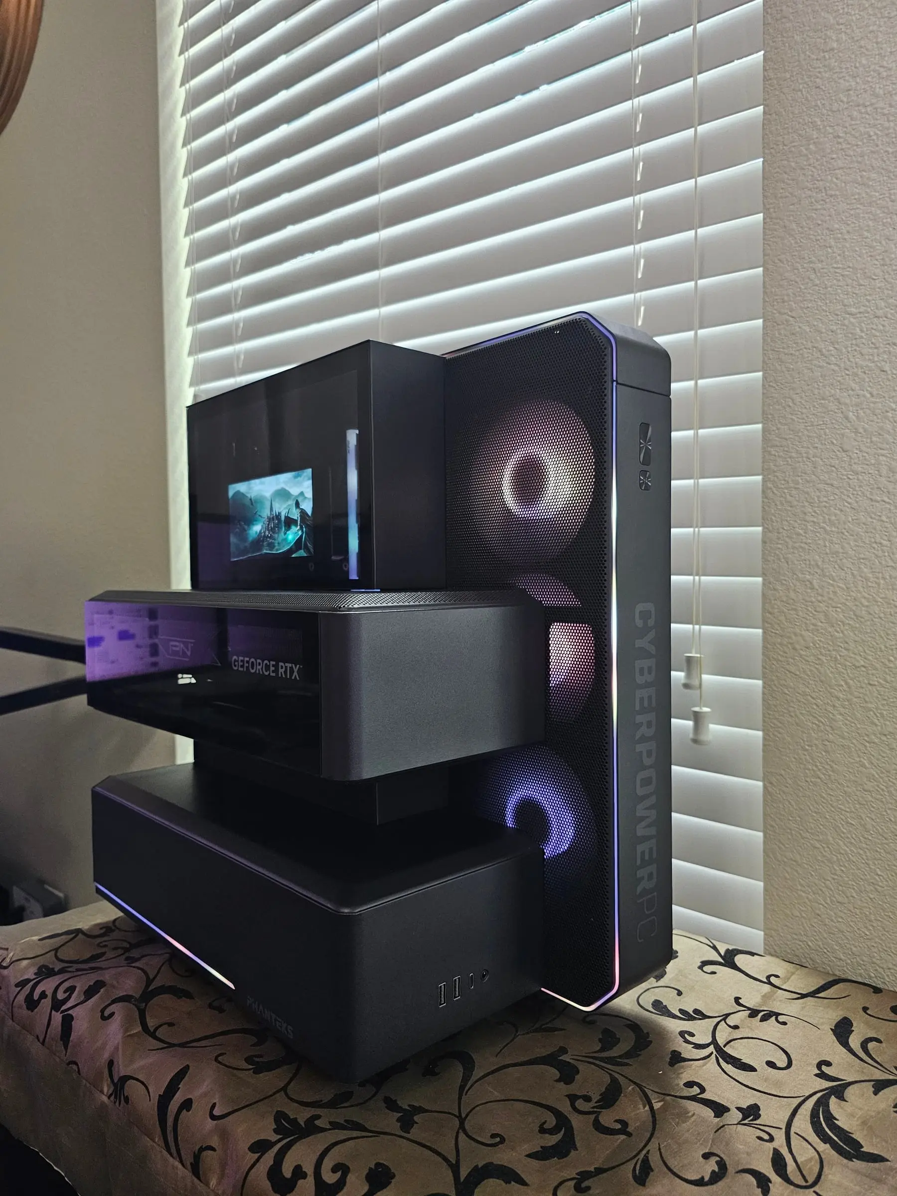 Phanteks EX5 with rainbow edge lighting tracing every module — CPU cube, floating GPU tray, and fan tower