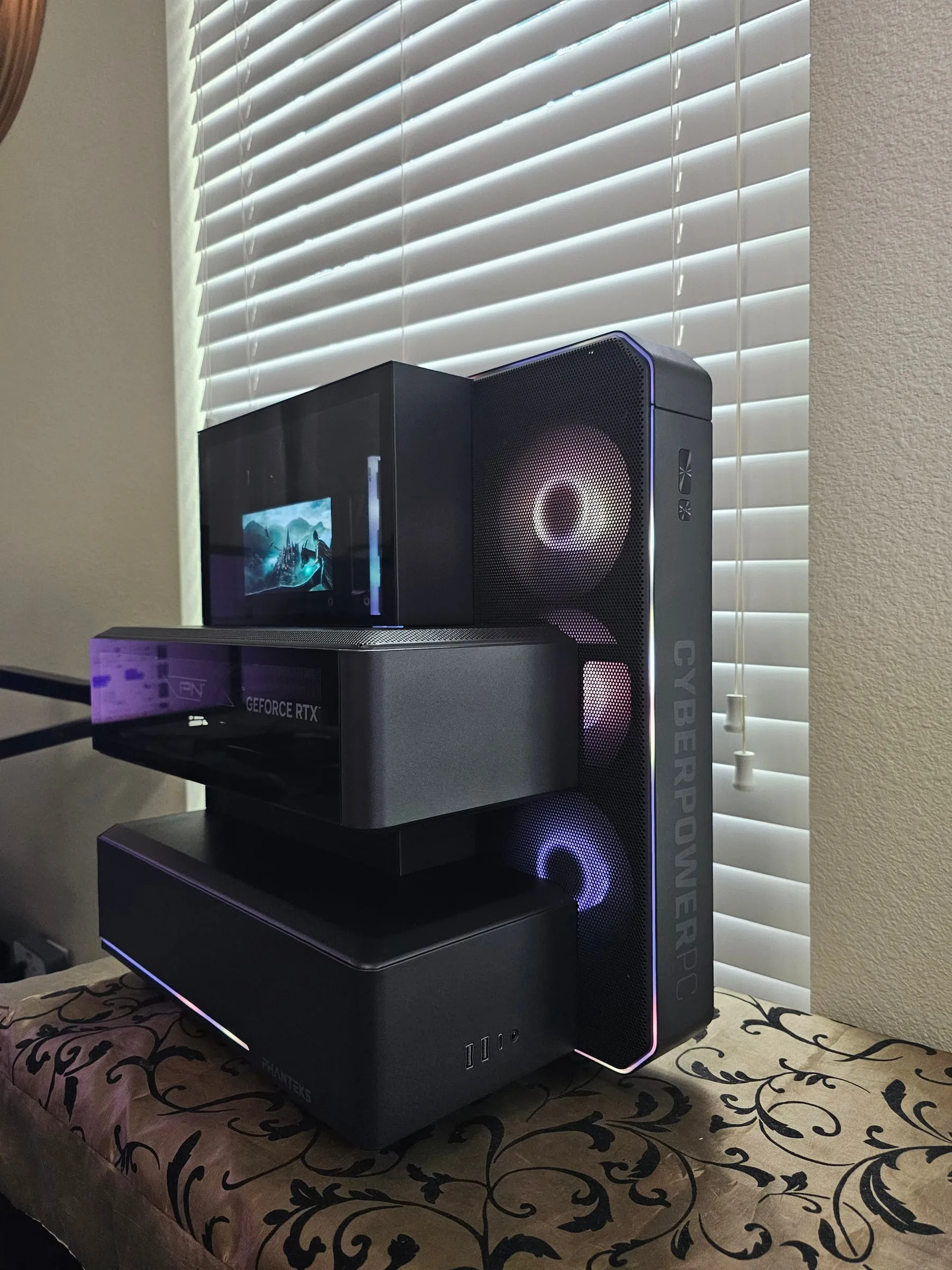 Phanteks EX5 with rainbow edge lighting tracing every module — CPU cube, floating GPU tray, and fan tower