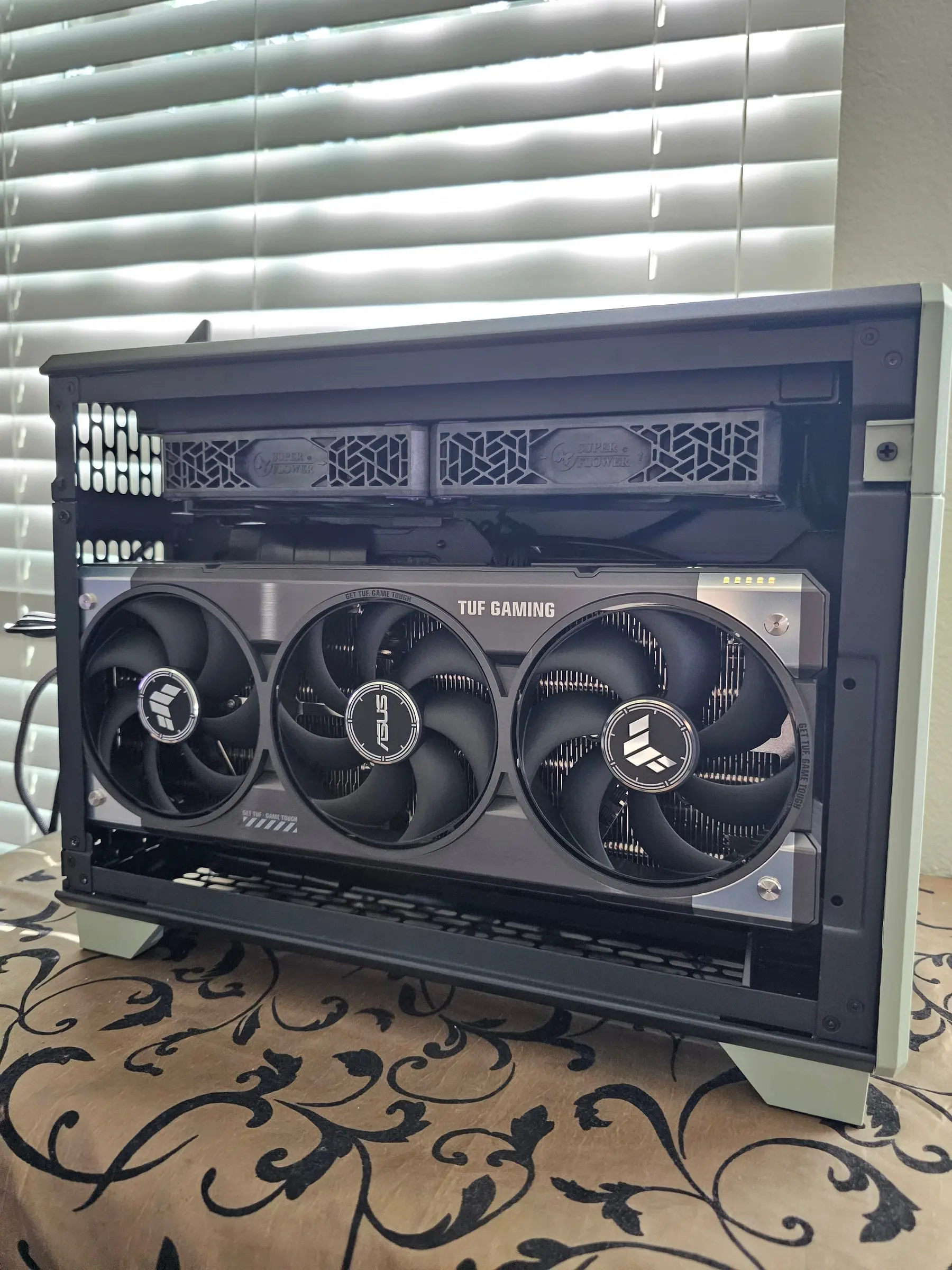 Rear panel removed to show the ASUS TUF Gaming graphics card and the Super Flower-branded SFX power supply mounted above it