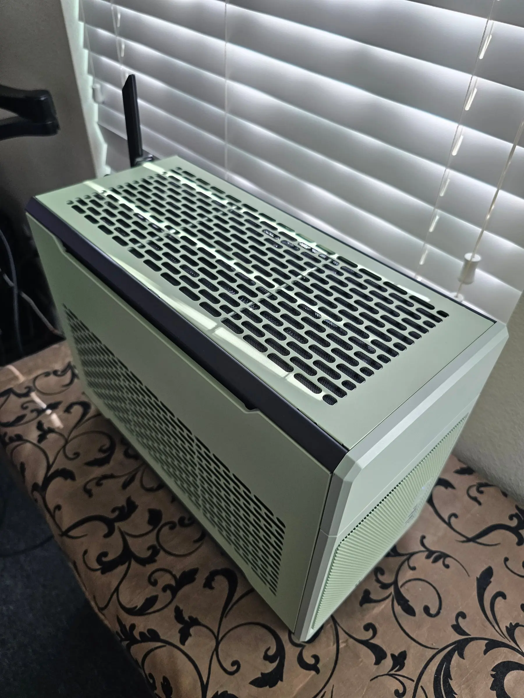 Top-back-left angle showing the mesh top panel and Wi-Fi antenna