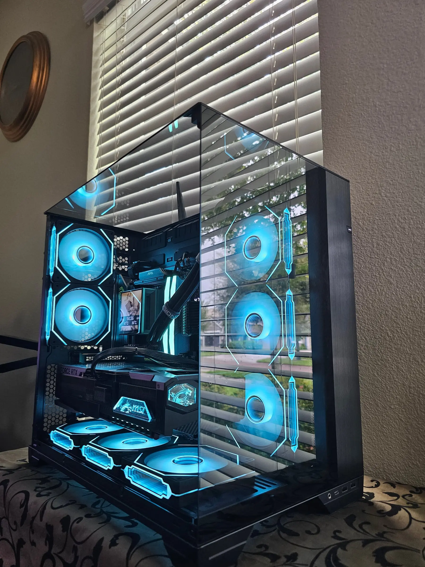 Ice-blue theme reflected across the tri-glass corner, MSI dragon crystal glowing on the GPU