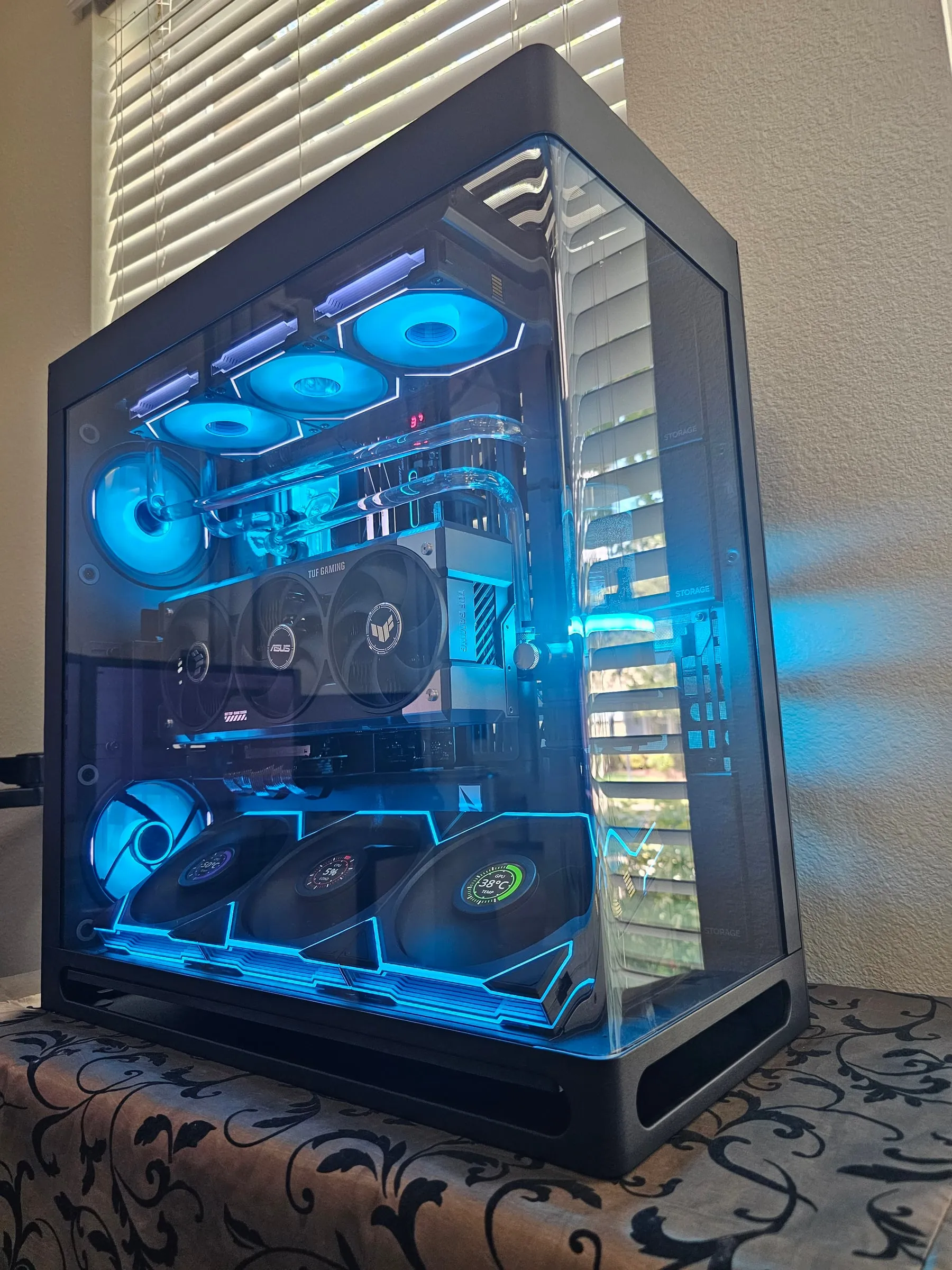 HS 420 custom loop in full cyan — acrylic runs, glowing reservoir, TUF RTX 5080, and live temp dials on the fan wall