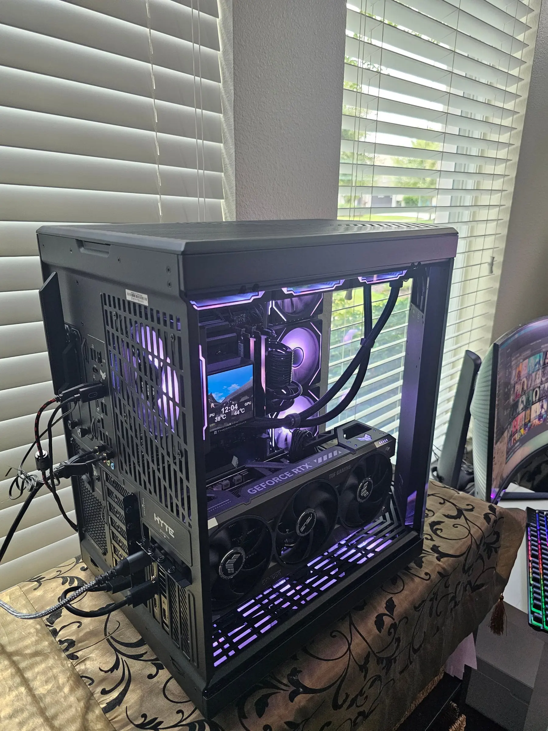 Rear-quarter interior view — AIO tubing, TUF RTX 5090, and Hyper Vision LCD in purple