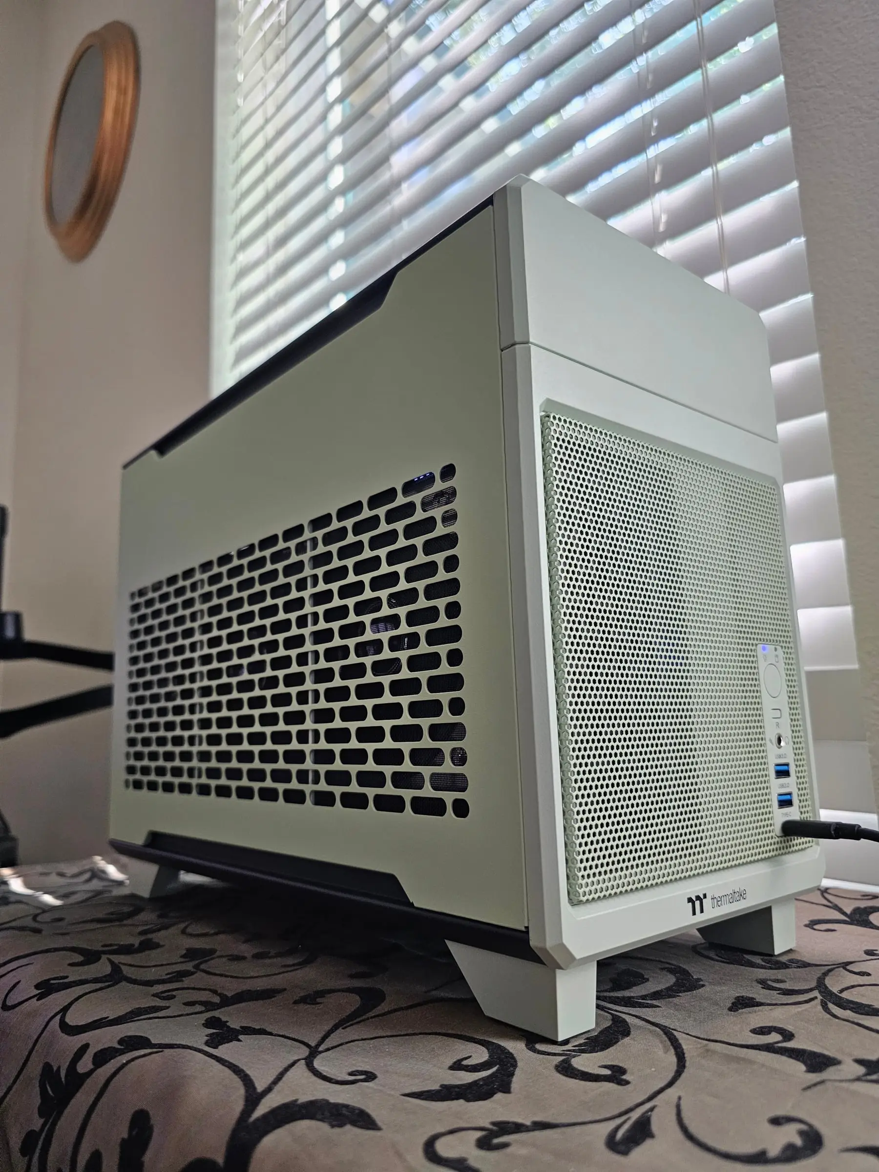Front-right angle with the case fully closed, status LED lit blue on the front mesh panel