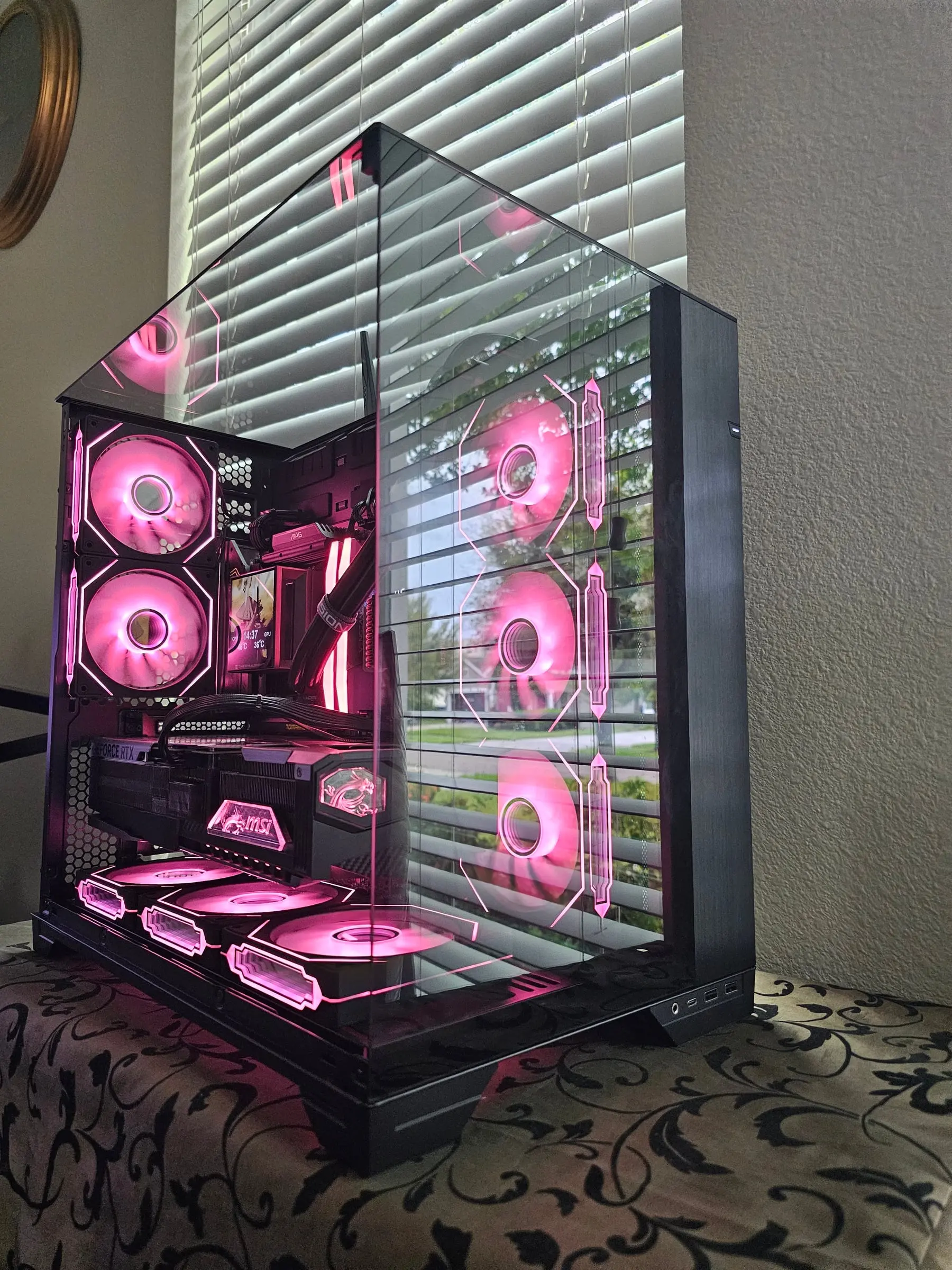 Pink theme — infinity mirror fans and red DDR5 light bars through the panoramic glass