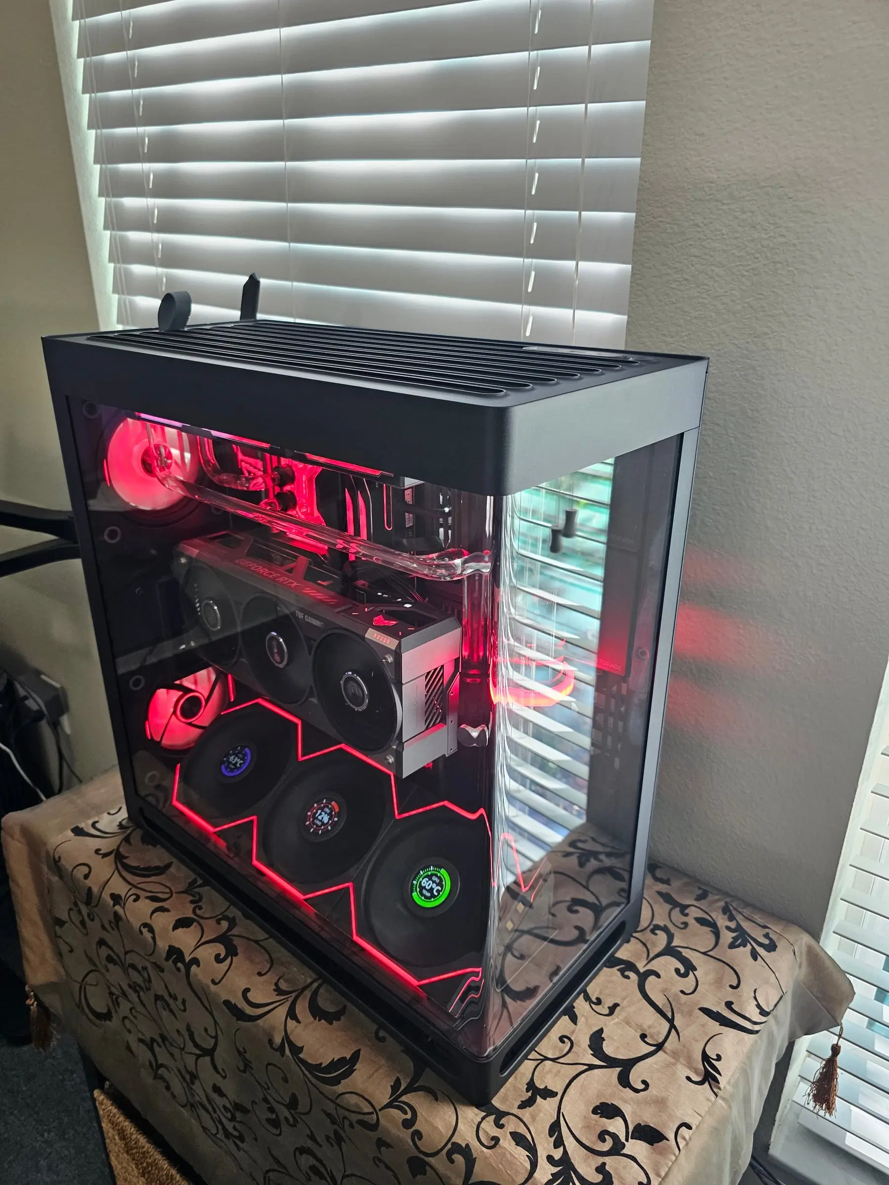 Red zigzag fan wall with the loop under load, dials showing CPU and GPU temps