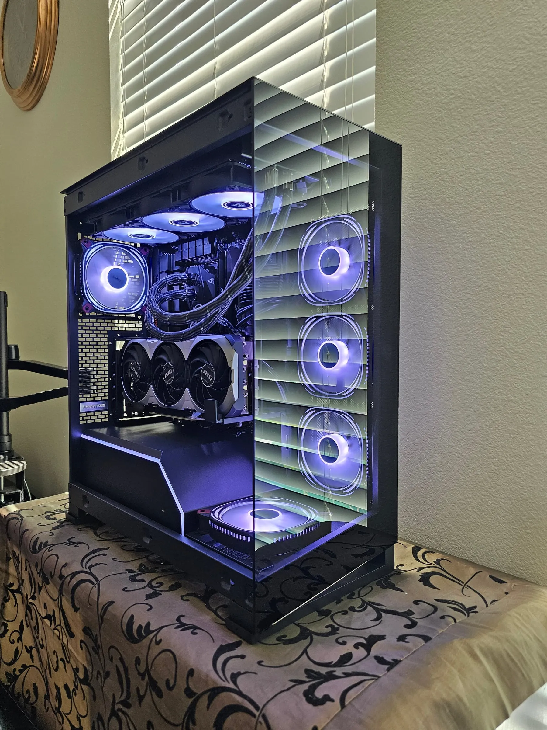 Open build with violet fans — MAG Coreliquid 360 up top, four Delta RGB sticks lit