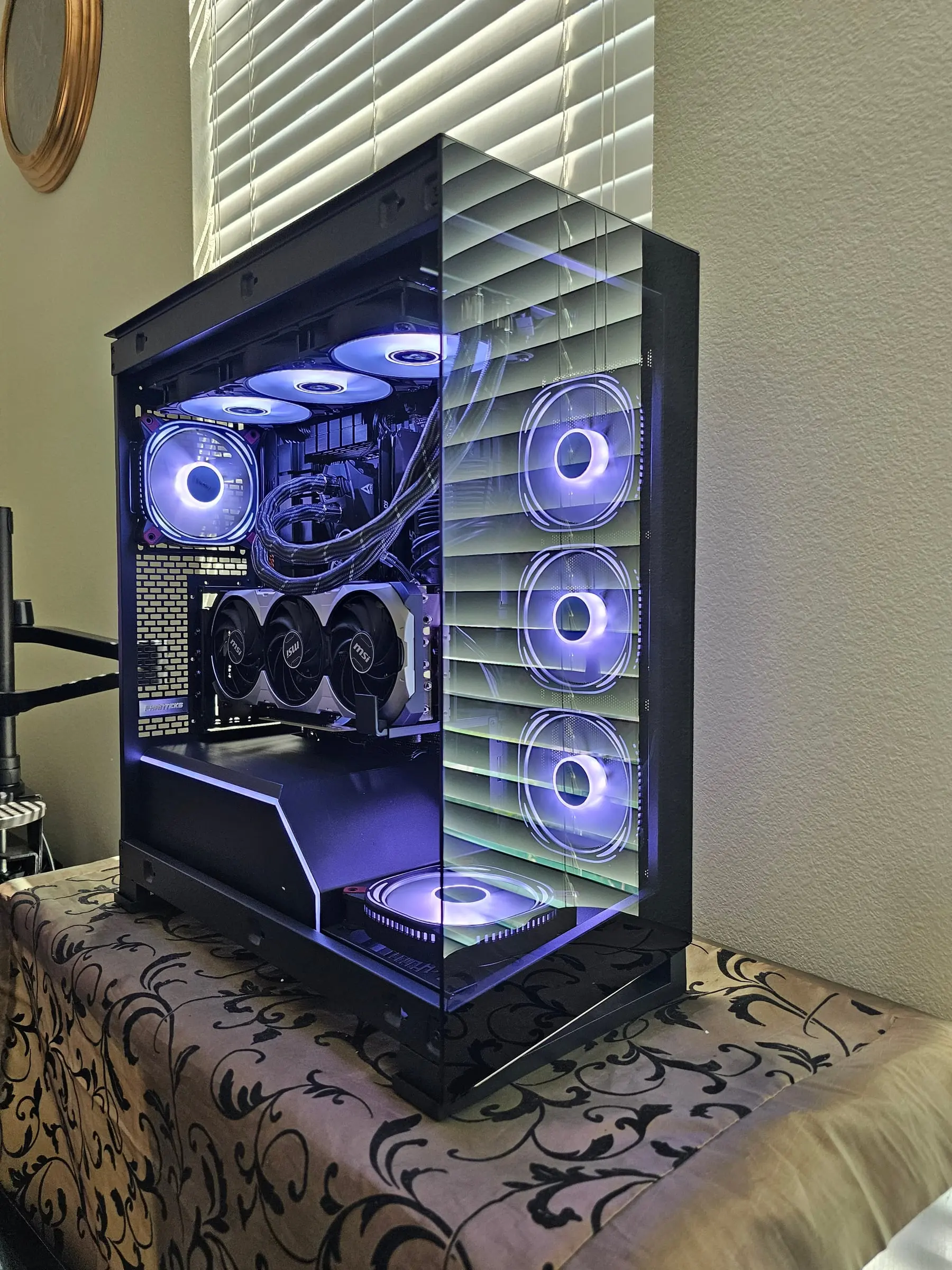 Open build with violet fans — MAG Coreliquid 360 up top, four Delta RGB sticks lit