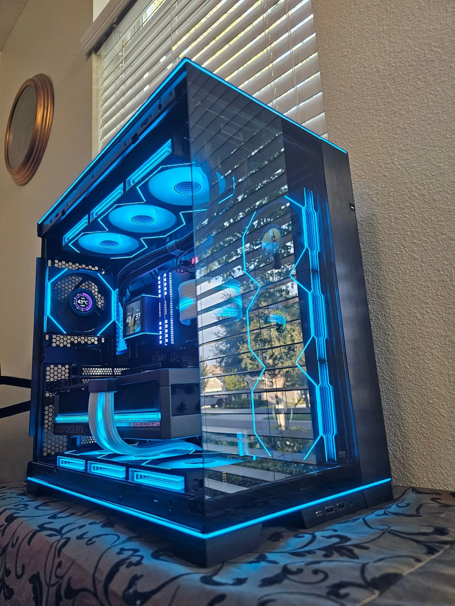 Bright cyan theme — frame strips and ten fans lit through the pillarless glass