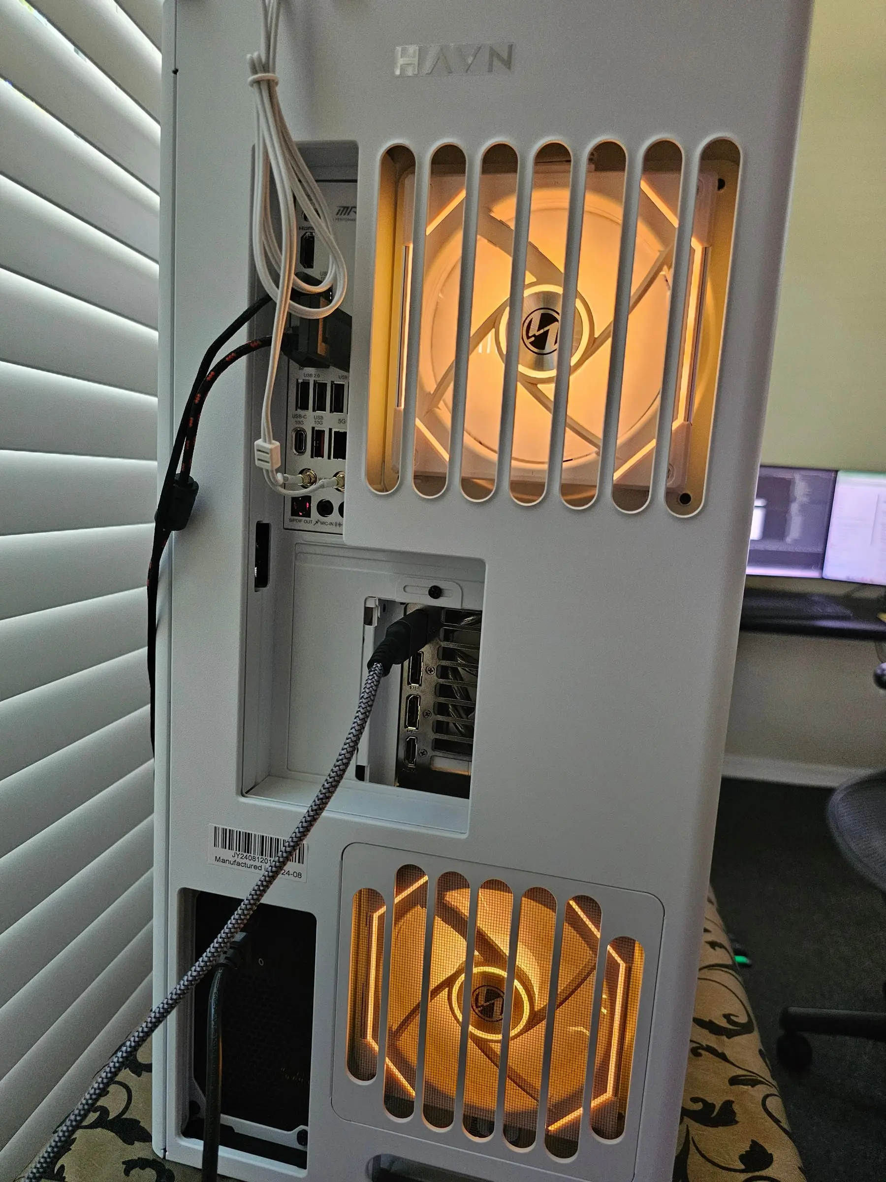 Rear of the HS 420 — HAVN badge, MSI rear I/O, and amber-lit exhaust fans through the vents