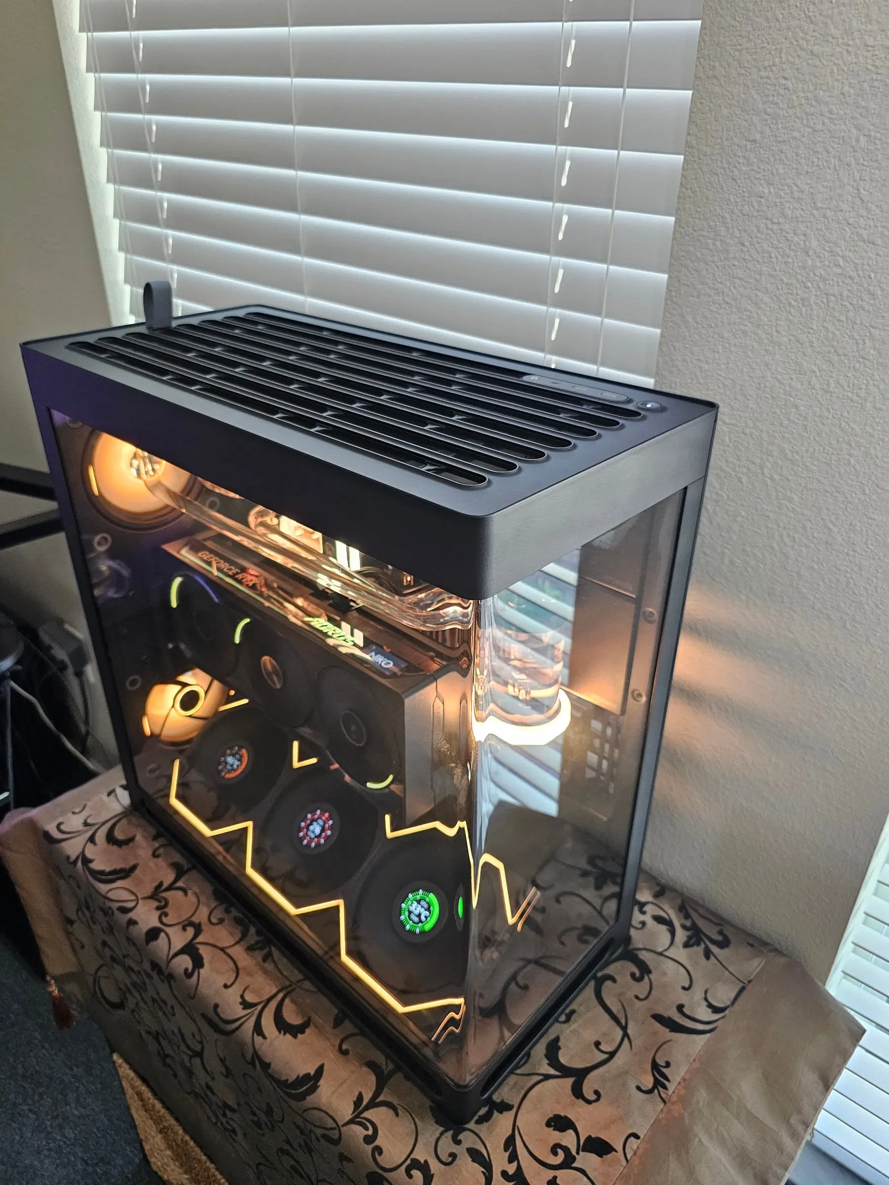 Amber theme from above — vented roof, warm-lit reservoir, and gold zigzag fan wall