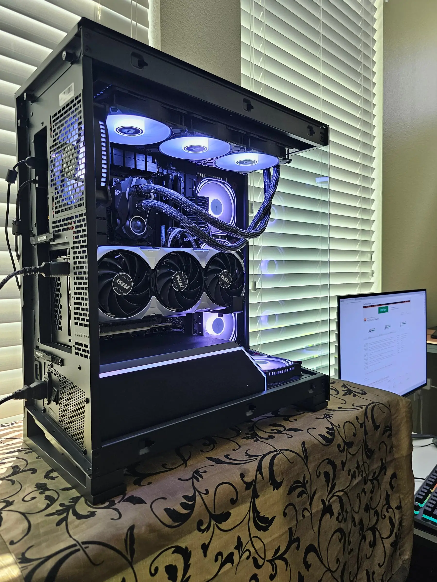 Violet theme from the rear quarter during benchmarking, monitor showing the test run