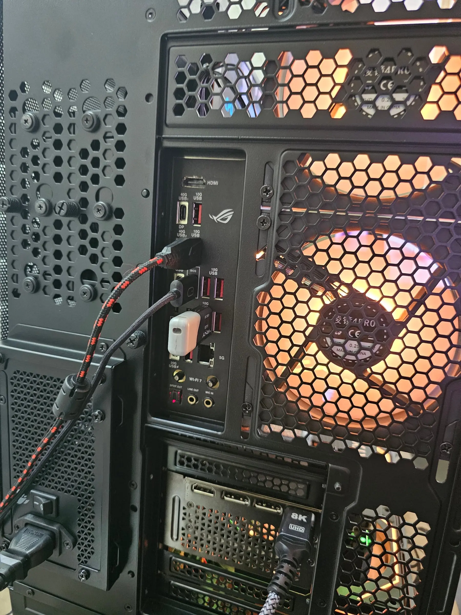 Rear I/O of the ROG Strix X870E-E — Wi-Fi 7, 40G USB4, and 5G LAN — with orange fans behind the mesh